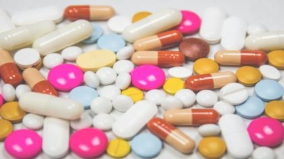 多種顏色與形狀的藥丸、藥片與膠囊堆疊在一起，示意藥物數量繁多